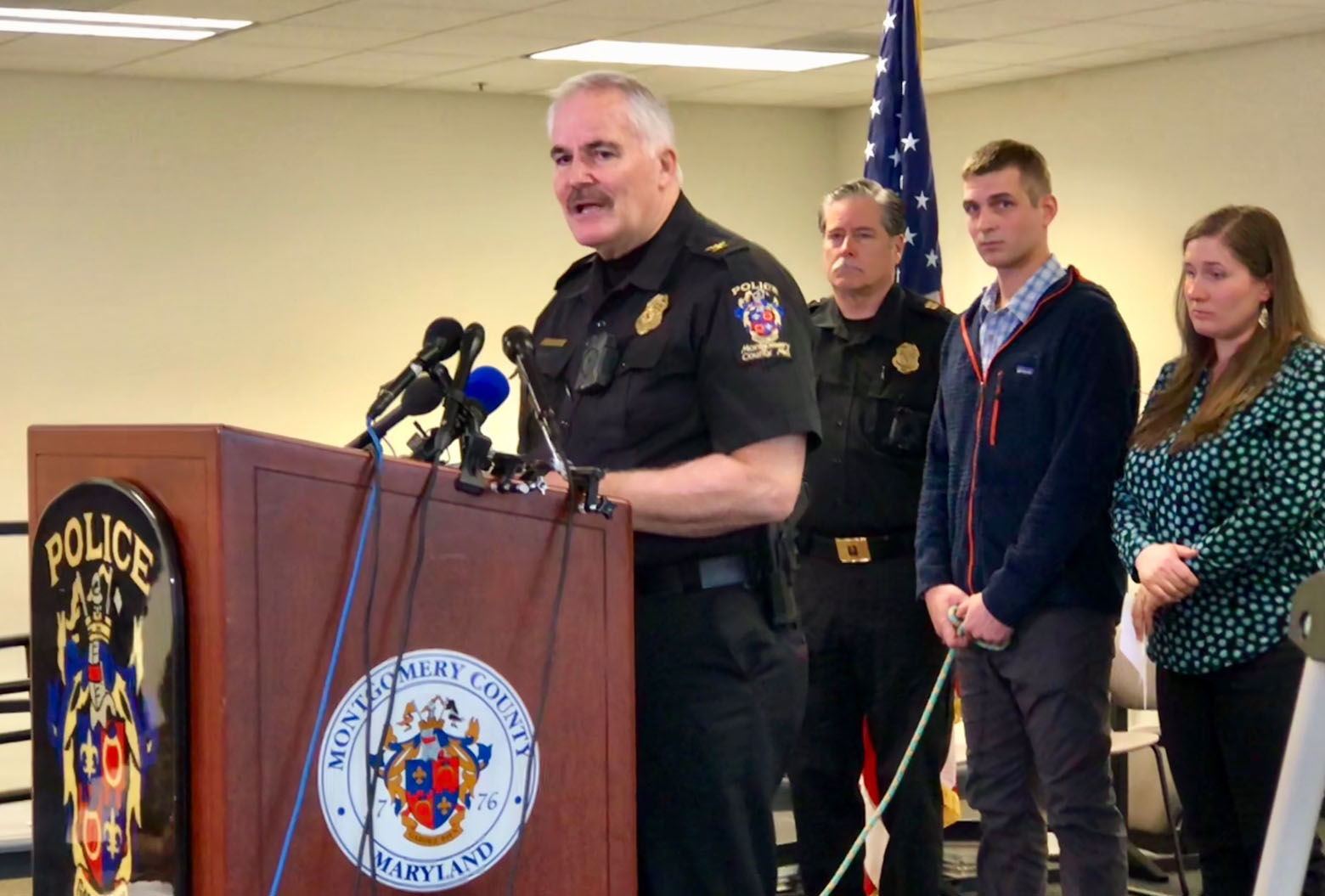 Montgomery County Police Chief Tom Manger speaks to reporters April 12, 2018. Sam Thresher and Hannah Thresher stand behind him. (WTOP/Megan Cloherty)