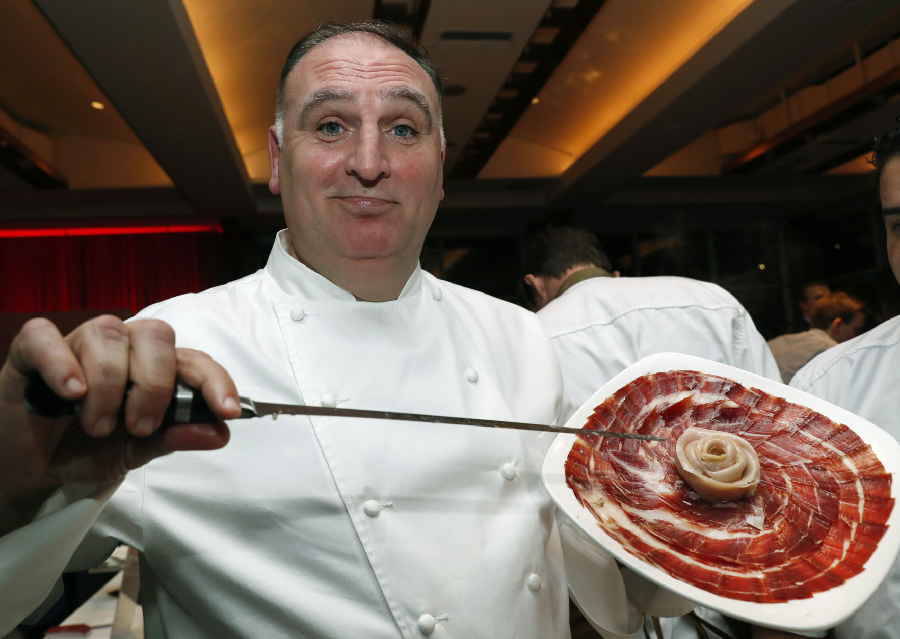Spanish chef Jose Andres displays 48-month cured ham from acorn-fed, free-range, black-footed Iberico pigs from Spain at his ThinkFoodGroup station, Tuesday, Feb. 27, 2018, during the Careers through Culinary Arts Program (C-CAP) annual benefit in New York. Andres was honored with the C-CAP Honors award, which is granted to individuals within the culinary industry for exceptional leadership and achievements. (AP Photo/Kathy Willens)