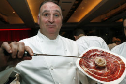 Spanish chef Jose Andres displays 48-month cured ham from acorn-fed, free-range, black-footed Iberico pigs from Spain at his ThinkFoodGroup station, Tuesday, Feb. 27, 2018, during the Careers through Culinary Arts Program (C-CAP) annual benefit in New York. Andres was honored with the C-CAP Honors award, which is granted to individuals within the culinary industry for exceptional leadership and achievements. (AP Photo/Kathy Willens)