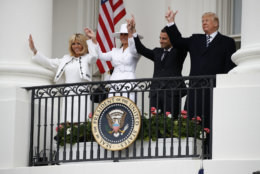 President Donald Trump, French President Emmanuel Macron, first lady Melania Trump and Brigitte Macron hold hands high from the White House balcony during a State Arrival Ceremony at the White House in Washington, Tuesday, April 24, 2018. (AP Photo/Carolyn Kaster)