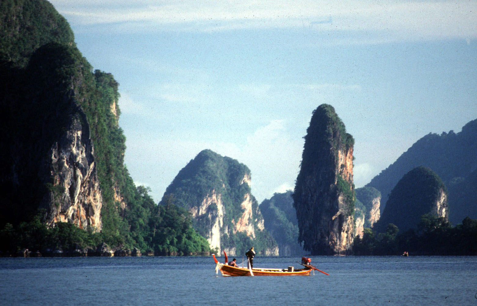 A fisherman's boat floats in Phang-Nga Bay in southern Thailand in 1997. Kayak tours to sea caves along the bay were meant to be a model of eco-tourism for Asia. But today, boats jam the narrow passages, tourists snap off stalactites for souvenirs, and their bellowing scares away gibbons, hornbills and other wildlife. (AP Photo/John Everingham)