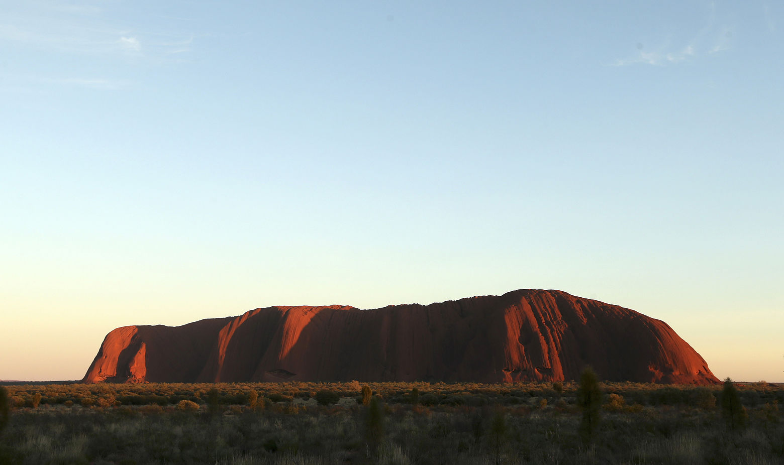 The sun rises over Uluru, Australia, Tuesday, April 22, 2014.  The Duke and Duchess of Cambridge will visit Uluru Tuesday during their three-week tour of Australia and New Zealand, the first official trip overseas with their son, Prince George. (AP Photo/Rob Griffith)