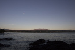 FILE - This Aug. 31, 2015 file photo shows Mauna Kea, Hawaii's tallest mountain and the proposed construction site for a giant $1.4 billion telescope project, as seen from Hilo, Hawaii. On Friday, April 13, 2018, officials with the Thirty Meter Telescope International Observatory have delayed a decision whether to continue efforts to construct it at its preferred site in Hawaii or at an alternate site in Spain's Canary Islands. (AP Photo/Caleb Jones, File)