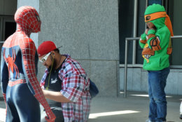 A young boy dressed as a character from the "Teenage Mutant Ninja Turtles" comic book and movie series smiles as he meets Spider Man at Awesome Con 2018 at the Walter E. Washington Convention Center in Washington, D.C. (Shannon Finney)