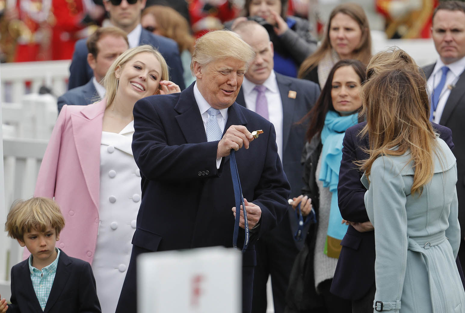 President Donald Trump holds out his whistle to first lady Melania Trump, right, during the annual White House Easter Egg Roll on the South Lawn of the White House in Washington, Monday, April 2, 2018. On the left is Trump's daughter Tiffany Trump. (AP Photo/Pablo Martinez Monsivais)