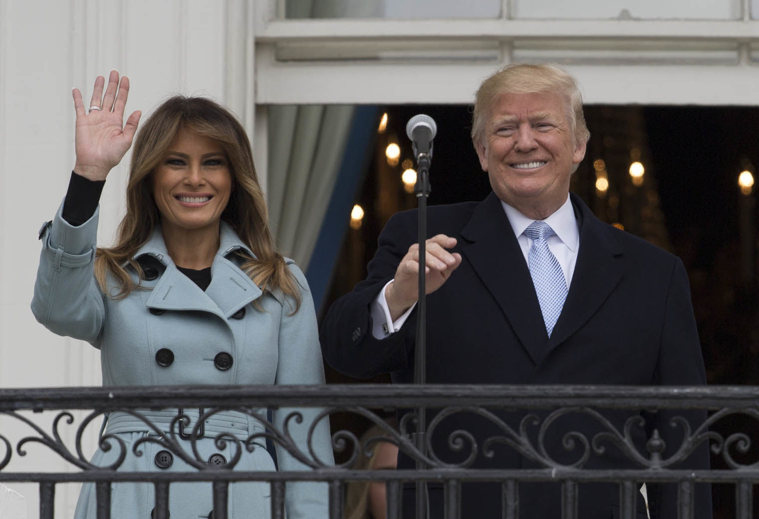 President Donald Trump and first lady Melania Trump wave from the Truman Balcony of the White House in Washington, Monday, April 2, 2018, during the annual White House Easter Egg Roll. (AP Photo/Carolyn Kaster)