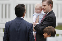 Donald Trump Jr., left, talks with his brother Eric Trump, left, holding son Luke, during the annual White House Easter Egg Roll on the South Lawn of the White House in Washington, Monday, April 2, 2018. (AP Photo/Pablo Martinez Monsivais)