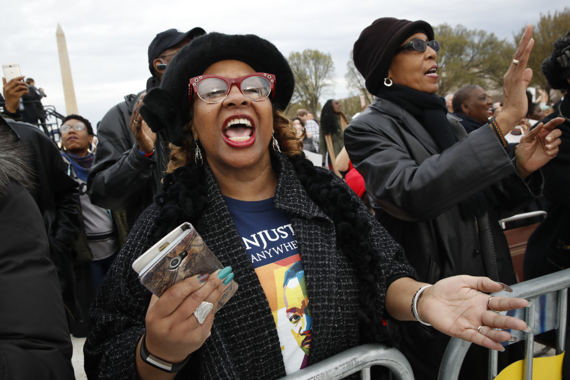 Wearing a t-shirt of Martin Luther King, Jr., Debra Payne, of Kansas City, Missouri, sings "This Little Light of Mine," next to Jo-Lynn Gilliam, of East Point, Ga., as they attend the A.C.T. To End Racism rally, Wednesday, April 4, 2018, on the National Mall in Washington, on the 50th anniversary of Martin Luther King, Jr.'s assassination. (AP Photo/Jacquelyn Martin)