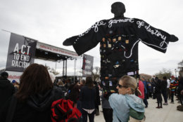 Molly Jackman, of Kensington, Md., holds up a sign with a silhouette of Martin Luther King Jr., while attending the A.C.T. To End Racism rally, Wednesday, April 4, 2018, on the National Mall in Washington, on the 50th anniversary of King's assassination. (AP Photo/Jacquelyn Martin)