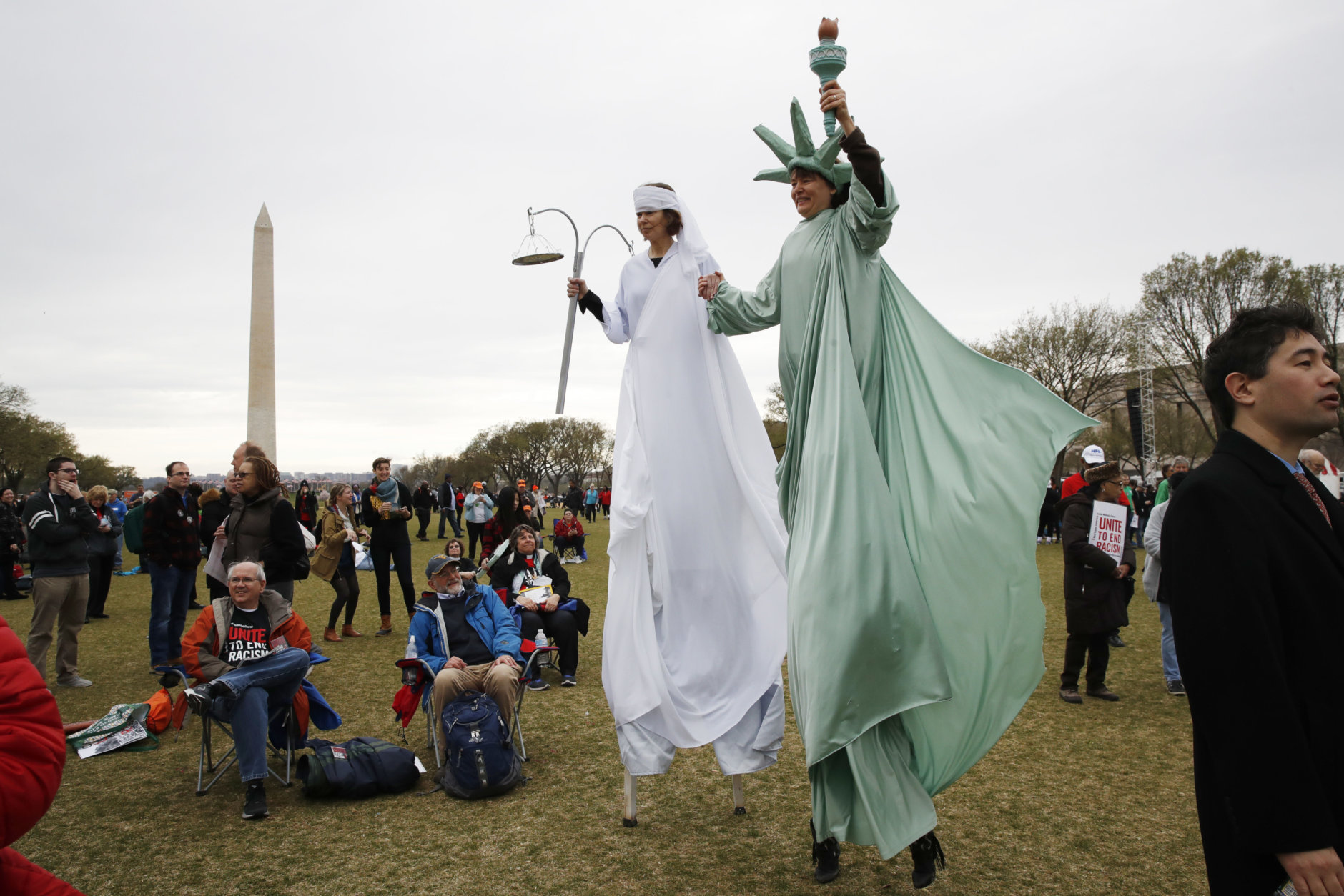 Carolyn McCarthy, dressed on stilts as "Lady Justice," left, and Debbie Davis, dressed as "Lady Liberty," both of Milwaukee, Wisc., attend the A.C.T. To End Racism rally, Wednesday, April 4, 2018, on the National Mall in Washington, on the 50th anniversary of Martin Luther King Jr.'s assassination. (AP Photo/Jacquelyn Martin)