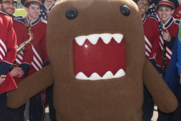 IMAGE DISTRIBUTED NHK WORLD - NHK WORLD-JAPAN's mascot, Domo, poses for a photo with members of the Austintown-Fitch High School marching band, from Austintown, Ohio, at the National Cherry Blossom Festival Parade on Saturday, April 14, 2018 in Washington. (Kevin Wolf/AP Images for NHK World)