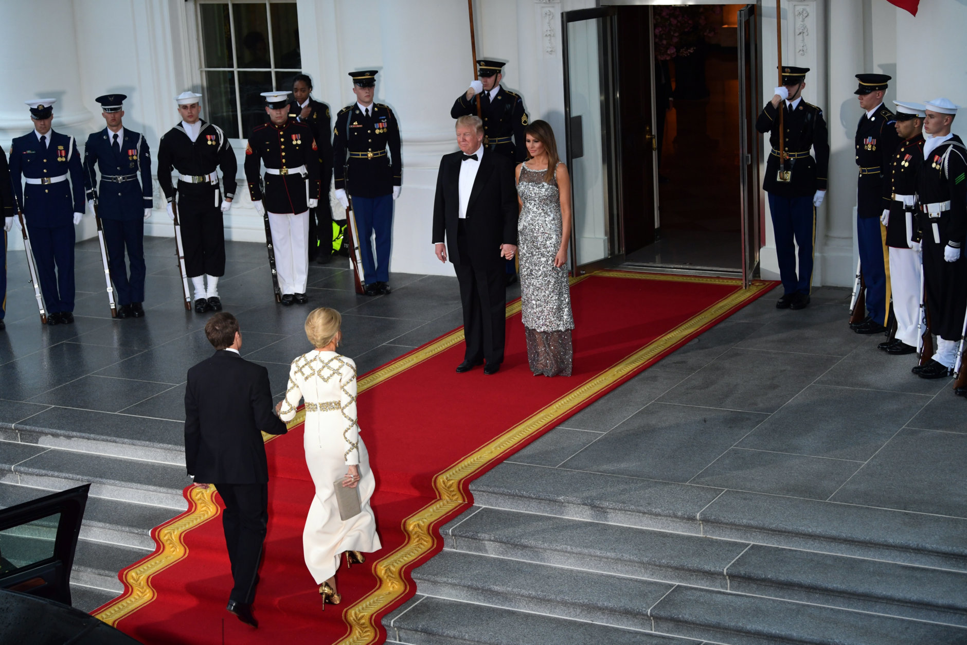 President Donald Trump and first lady Melania Trump wait to greet French President Emmanuel Macron and his wife Brigitte Macron as they arrive for a State Dinner at the White House in Washington, Tuesday, April 24, 2018. (AP Photo/Susan Walsh)