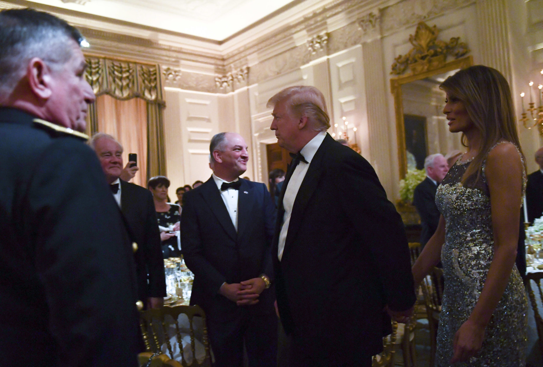 President Donald Trump, center, and first lady Melania Trump, right, walk into the State Dining Room to attend a State Dinner with French President Emmanuel Macron at the White House in Washington, Tuesday, April 24, 2018. (AP Photo/Susan Walsh)