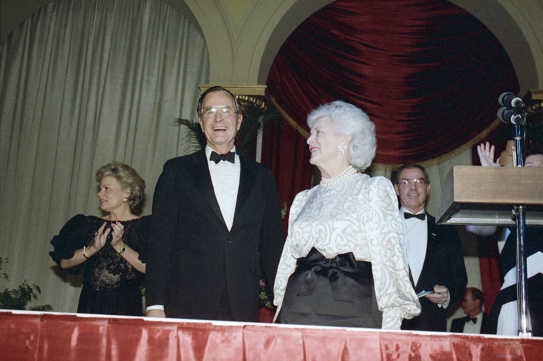 President-elect George H. W. Bush, left, and his wife, Barbara, right, smile at well-wishers during their second inaugural ball of the evening at the Pension Building, Jan. 18, 1989, Washington, D.C. (AP Photo/Marcy Nighwander)