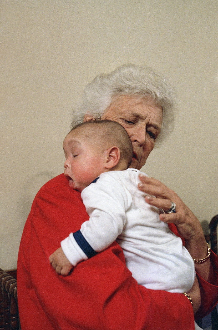 First lady Barbara Bush holds an infant identified as Donavan during a visit to Grandma's House in Washington, March 22, 1989. (AP Photo/Dennis Cook)