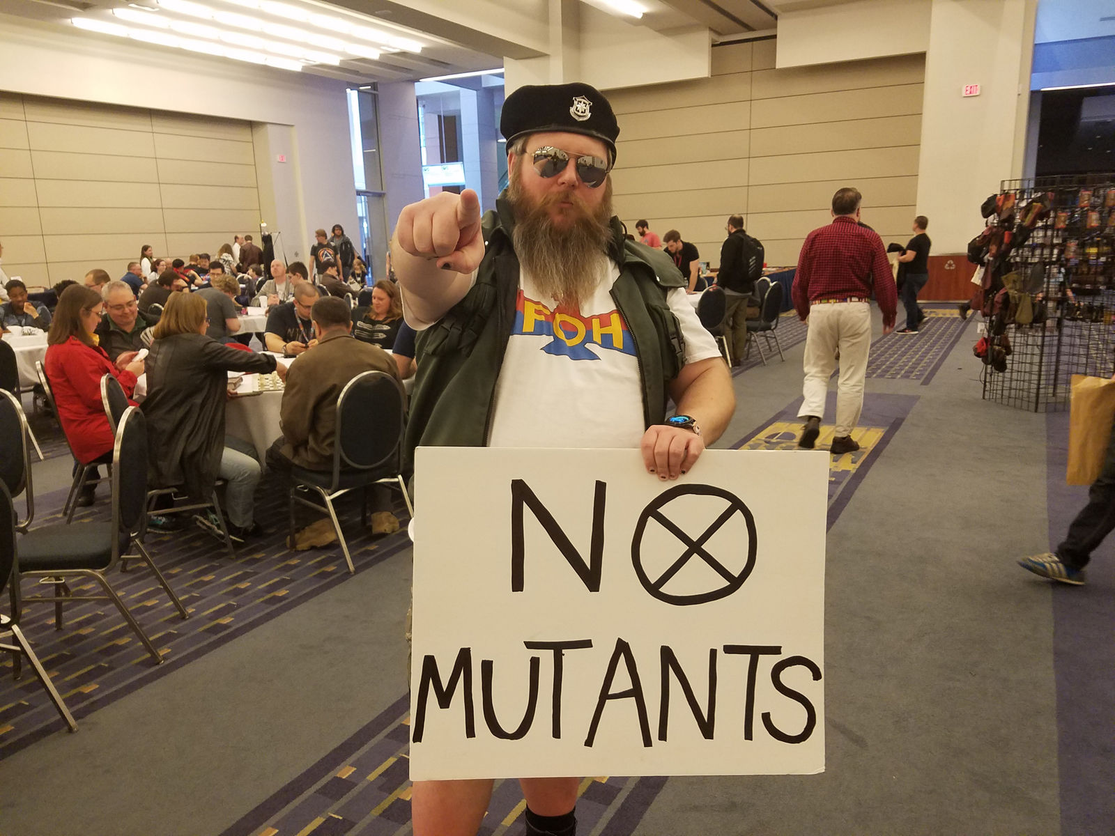 A man holds a sign espousing anti-mutant views at AwesomeCon 2018. (WTOP/Will Vitka)