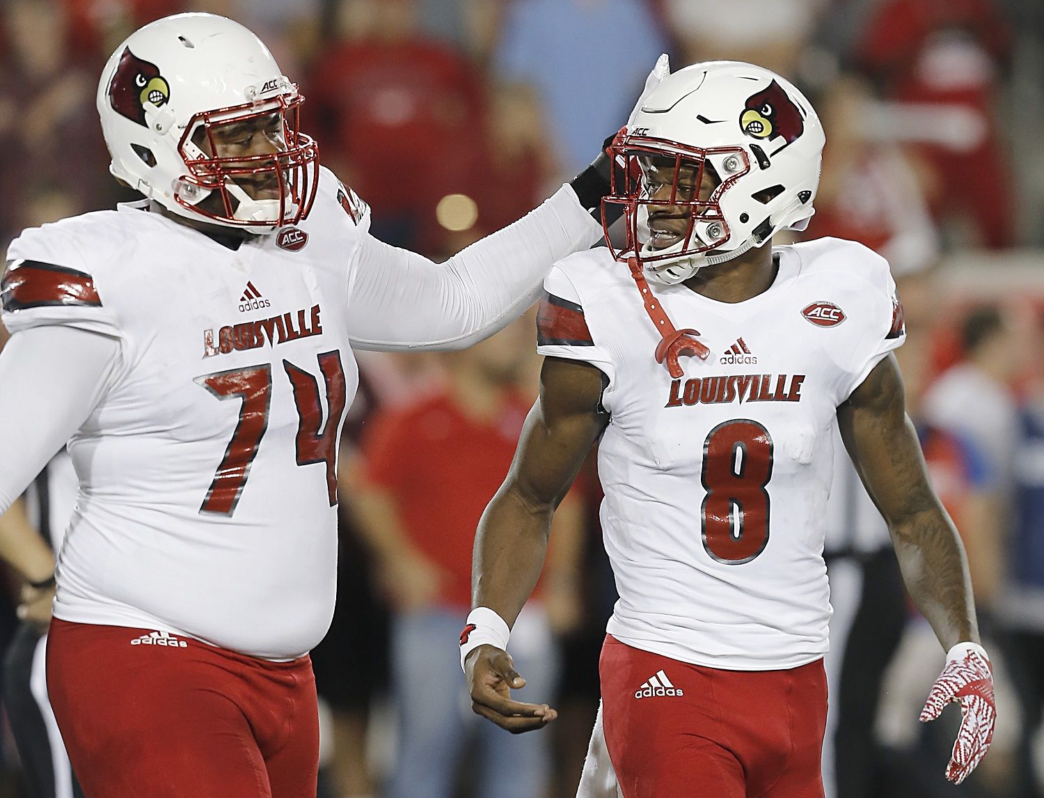 HOUSTON, TX - NOVEMBER 17: Offensive lineman Geron Christian #74 taps the head of quarterback Lamar Jackson #8 of the Louisville Cardinals while he walks off the field against the Houston Cougars in the second quarter at TDECU Stadium on November 17, 2016 in Houston, Texas. (Photo by Thomas B. Shea/Getty Images)