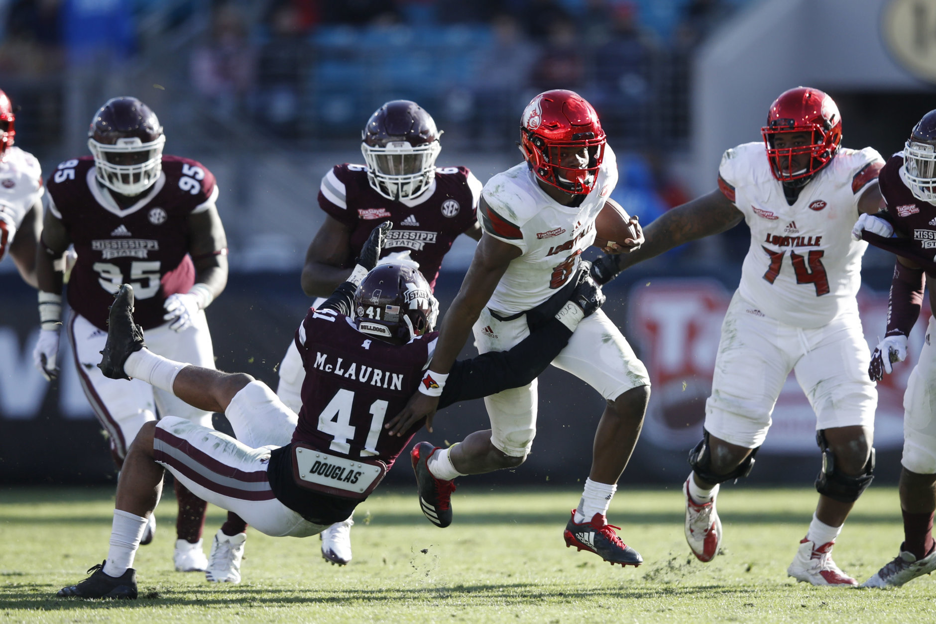 JACKSONVILLE, FL - DECEMBER 30: Mark McLaurin #41 of the Mississippi State Bulldogs tackles Lamar Jackson #8 of the Louisville Cardinals in the fourth quarter of the TaxSlayer Bowl at EverBank Field on December 30, 2017 in Jacksonville, Florida. The Bulldogs won 31-27. (Photo by Joe Robbins/Getty Images)