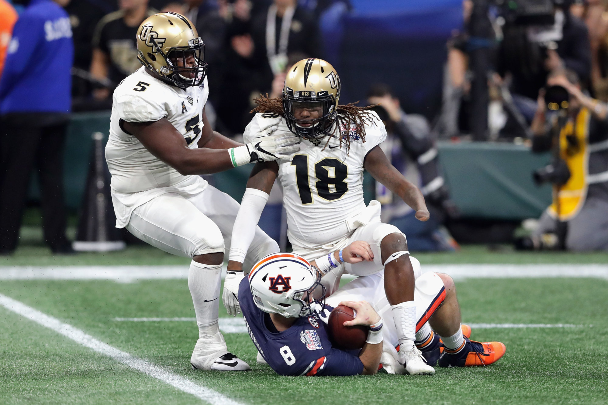 ATLANTA, GA - JANUARY 01:  Shaquem Griffin #18 of the UCF Knights steps over Jarrett Stidham #8 of the Auburn Tigers after making a sack in the second quarter during the Chick-fil-A Peach Bowl at Mercedes-Benz Stadium on January 1, 2018 in Atlanta, Georgia.  (Photo by Streeter Lecka/Getty Images)