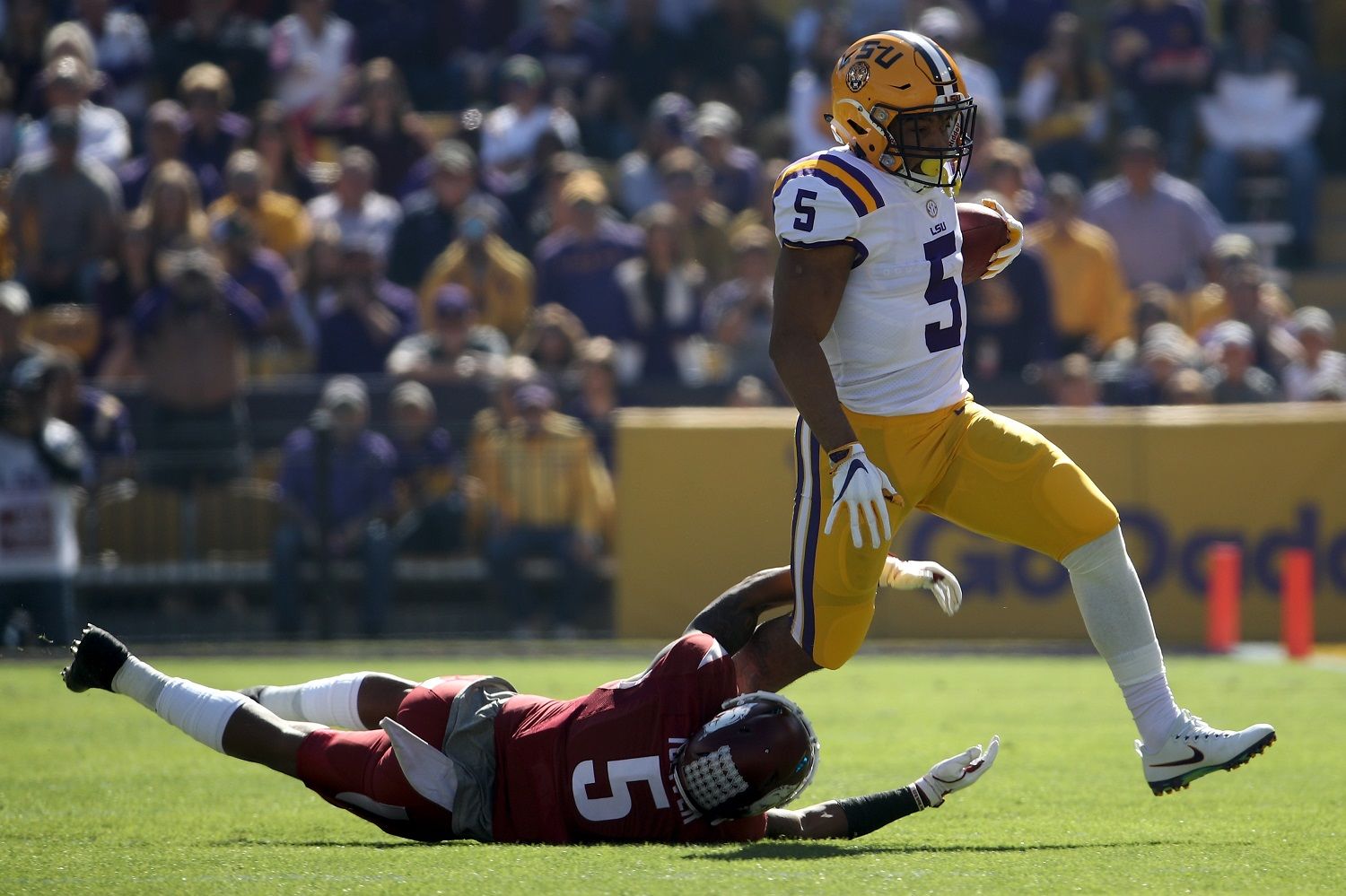 BATON ROUGE, LA - NOVEMBER 11:  Derrius Guice #5 of the LSU Tigers avoids a tackle by Henre' Toliver #5 of the Arkansas Razorbacks at Tiger Stadium on November 11, 2017 in Baton Rouge, Louisiana.  (Photo by Chris Graythen/Getty Images)