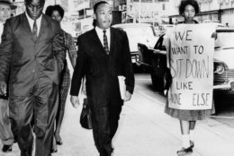 Dr. Martin Luther King Jr. under arrest by Atlanta Police Captain R.E. Little, left rear, passes through a picket line in front of a downtown department store on Oct. 9, 1960.  with King is another demonstration leader, Lonnie King and an unidentified woman.  The integration leader was among the 48 African-Americans arrested following demonstrations at several department and variety stores protesting lunch counter segregation.  (AP Photo/stf)