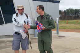 Glyn Gogherty, with the Royal Air Force handed out British flags to people at the Smithsonian's Air and Space Museum near Dulles Airport to celebrate the RAF's 100th birthday. (WTOP/Kathy Stewart)