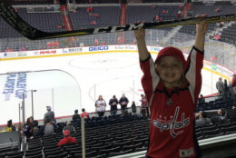 Keelan Moxley holds up a signed stick she received from Washington Capitals player Brett Connolly. (Courtesy Monumental Sports & Entertainment)