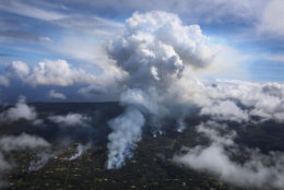 PAHOA, HI - MAY 06:  A plume of volcanic gas mixed with smoke from fires caused by lava rises (C) amidst clouds in the Leilani Estates neighborhood in the aftermath of eruptions from the Kilauea volcano on Hawaii's Big Island on May 6, 2018 in Pahoa, Hawaii. A magnitude 6.9 earthquake struck the island May 4. The volcano has spewed lava and high levels of sulfur dioxide gas into communities, leading officials to order 1,700 to evacuate. Officials have confirmed 26 homes have now been destroyed by lava in Leilani Estates.  (Photo by Mario Tama/Getty Images)