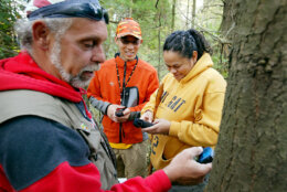 Geocachers Bob Rathbone, left, Robin Bright, right, and new geocacher Sang Park, center, program the next destination into their GPS units, while searching for caches in the New Munster Wildlife Park, Friday October 21, 2005 in New Munster, Wisconsin.  An estimated one million people worldwide have played the scavenger hunt game that has a high-tech twist. In fact, geocaching is becoming popular enough that numerous states now post online the coordinates of local sites of interest to encourage state tourism. (AP Photo/ Ron Kuenstler)