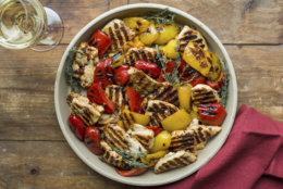This April 2017 photo shows grilled lemony chicken and peppers in New York. This dish is from a recipe by Katie Workman. (Sarah Crowder via AP)