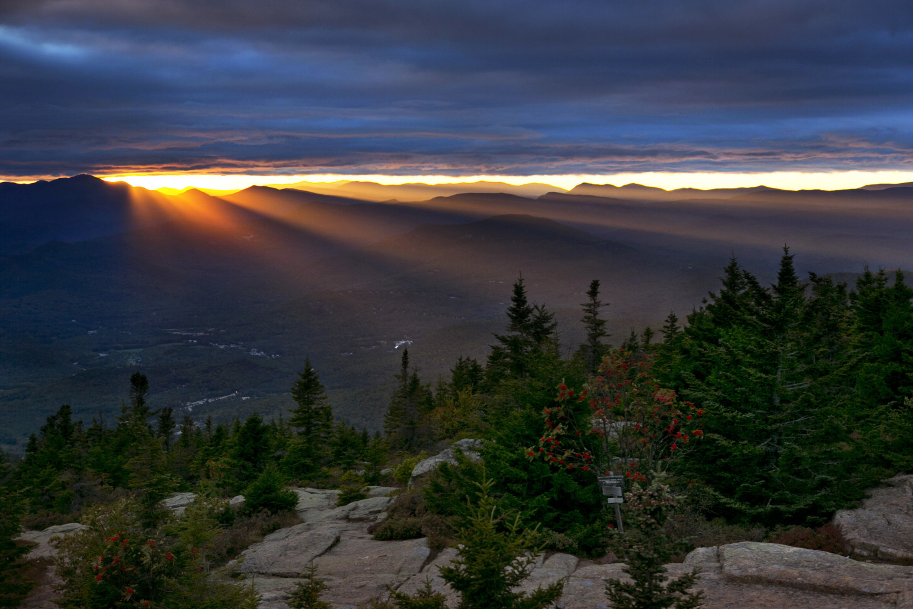 Sun rays spill through a gap between the clouds and the White Mountains as the skies begin to clear above Bartlett, N.H., Friday, Sept. 22, 2017. The first weekend of autumn is expected to be unusually warm with temperatures expected to reach the upper 80s. (AP Photo/Robert F. Bukaty)
