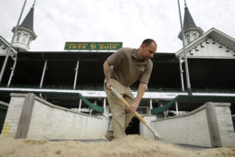 A worker scoops dirt back onto the track after morning training for race horses at Churchill Downs Wednesday, May 2, 2018, in Louisville, Ky. The 144th running of the Kentucky Derby is scheduled for Saturday, May 5. (AP Photo/Charlie Riedel)