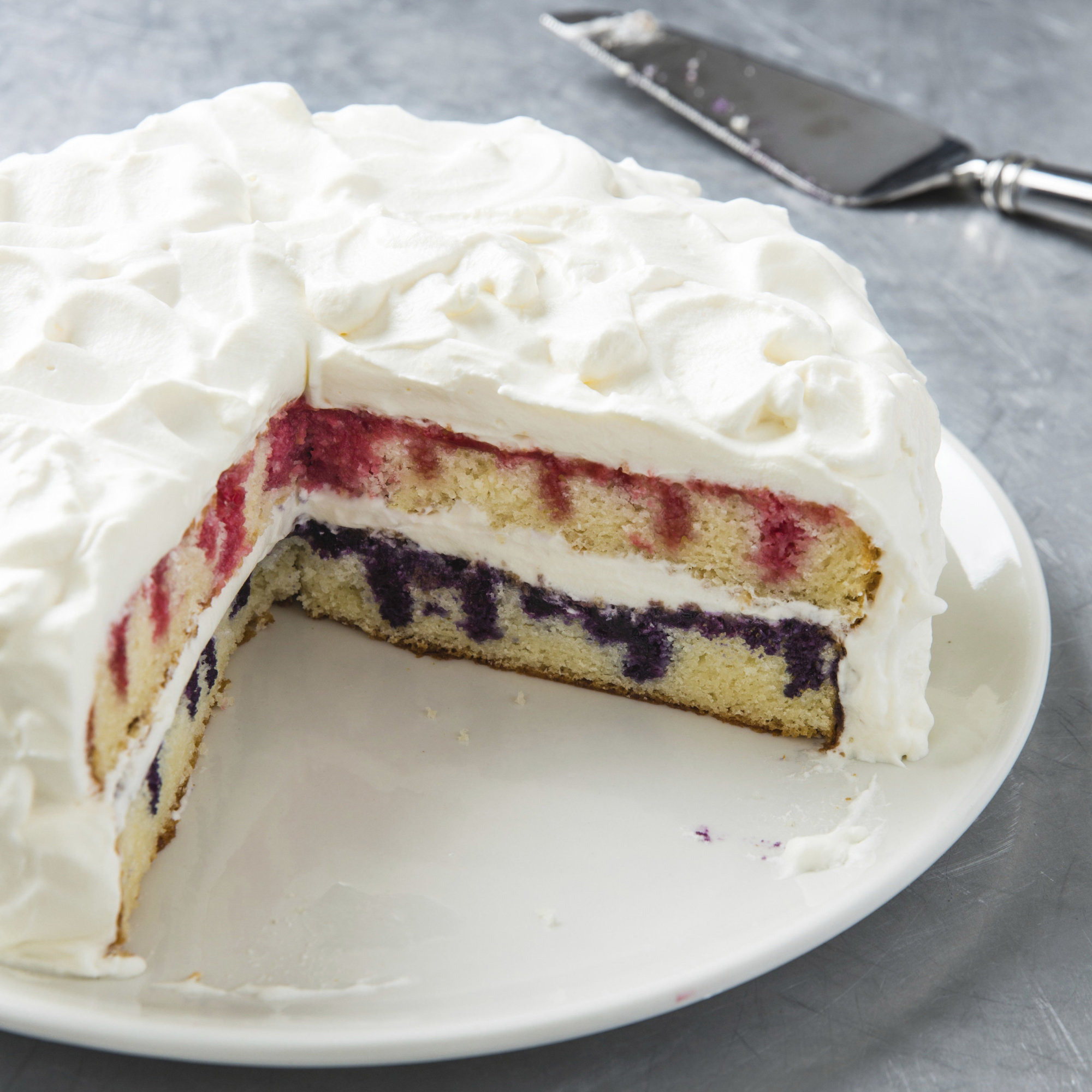 This undated photo provided by America's Test Kitchen in May 2018 shows patriotic poke cake in Brookline, Mass. This recipe appears in the cookbook “The Perfect Cake.” (Joe Keller/America's Test Kitchen via AP)