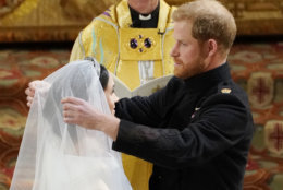 Britain's Prince Harry pulls back the veil of Meghan Markle watched by Archbishop of Canterbury Justin Welby during their wedding at St. George's Chapel in Windsor Castle in Windsor, near London, England, Saturday, May 19, 2018. (Owen Humphreys/pool photo via AP)