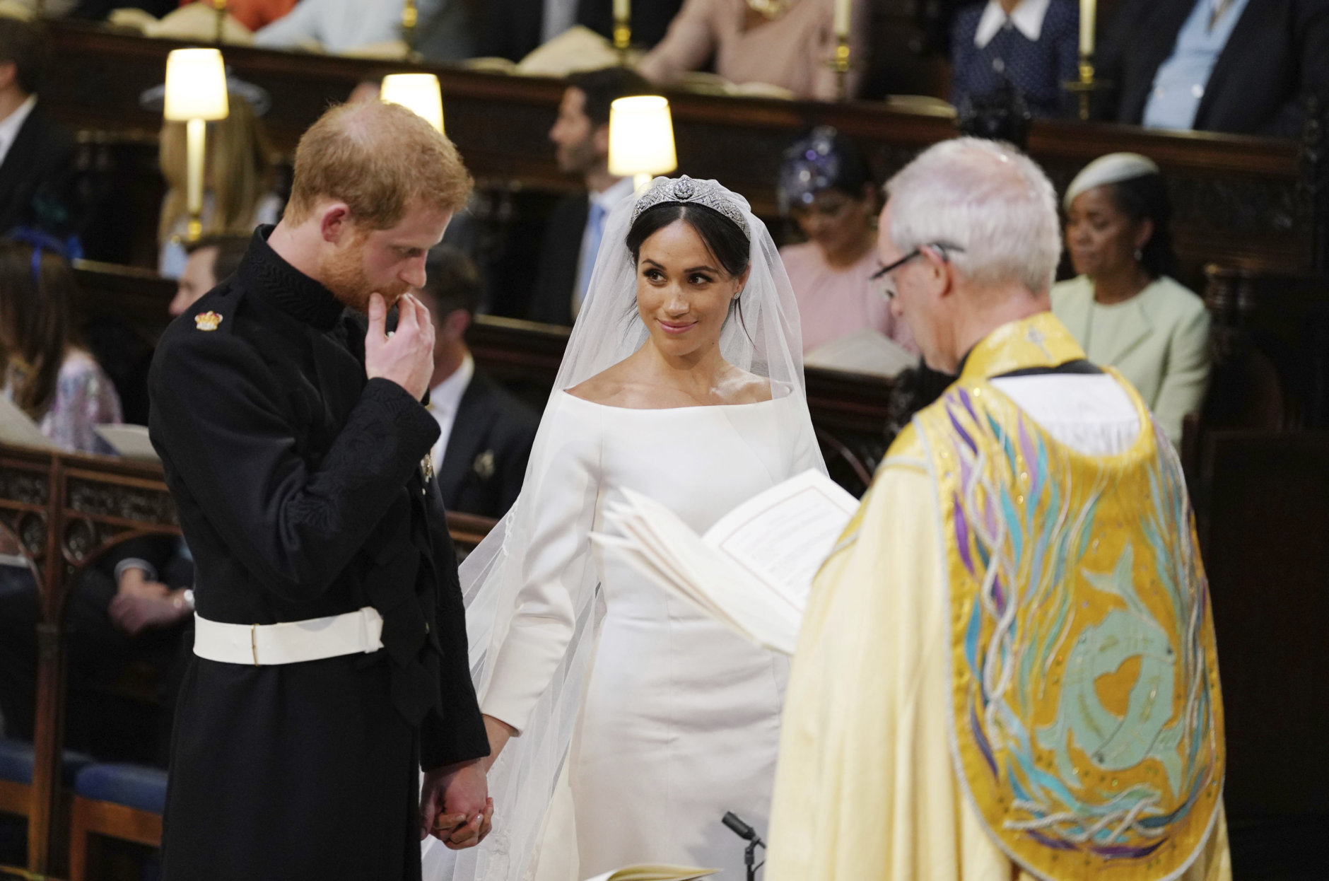 Britain's Prince Harry and Meghan Markle hold hands in St George's Chapel at Windsor Castle during their wedding service, conducted by the Archbishop of Canterbury Justin Welby in Windsor, near London, England, Saturday, May 19, 2018. (Dominic Lipinski/pool photo via AP)