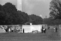 Workmen set up flooring and A-frames for the wooden camp near Lincoln Memorial to house the Poor Peoples Campaign demonstrators in Washington, May 13, 1968. A federal permit allows the demonstrators to occupy the 15-acre area until on June 16 and limits occupants to 3,000. In background is the Washington Monument. (AP Photo/Bob Schutz)
