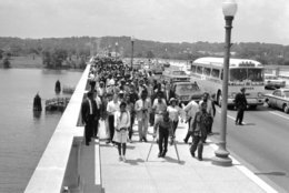 This group of newly-arrived demonstrators of the Poor People's Campaign walk across Memorial Bridge, spanning the Potomac River, May 22, 1968, to the plywood encampment at Resurrection City, USA. The new arrivals who have been staying in Northern Virginia churches since Sunday, are from Alabama, Mississippi, Georgia, North Carolina and Virginia. In background high on the slope of Arlington National Cemetery is the Lee Mansion. (AP Photo/Charles Tasnadi)