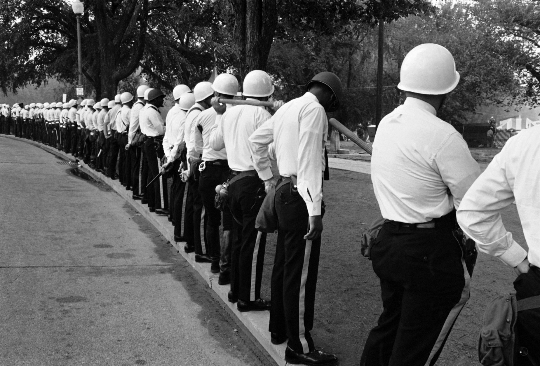 A line of helmeted police stand shoulder to shoulder just outside an entrance to Resurrection City, the encampment of the Poor People's Campaign in Washington, June 24, 1968. The permit allowing the encampment ended last night and police were on hand to clear out any residents who remain. (AP Photo/Bob Daugherty)
