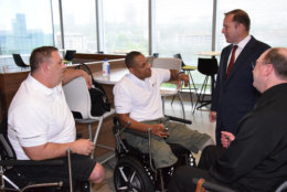 Pictured here are recipients of Segway chairs, funded by the PenFed Foundation: from left, Staff Sgt. Dustin Tuller and retired Master Sgt. Cedric King talk with PenFed President and CEO James Schenck and Jerry Kerr of Seg4Vets, far right. (Courtesy PenFed)