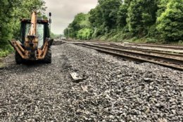 Tons of gravel in dump trucks have been replaced along flooded tracks. (WTOP/Neal Augenstein)