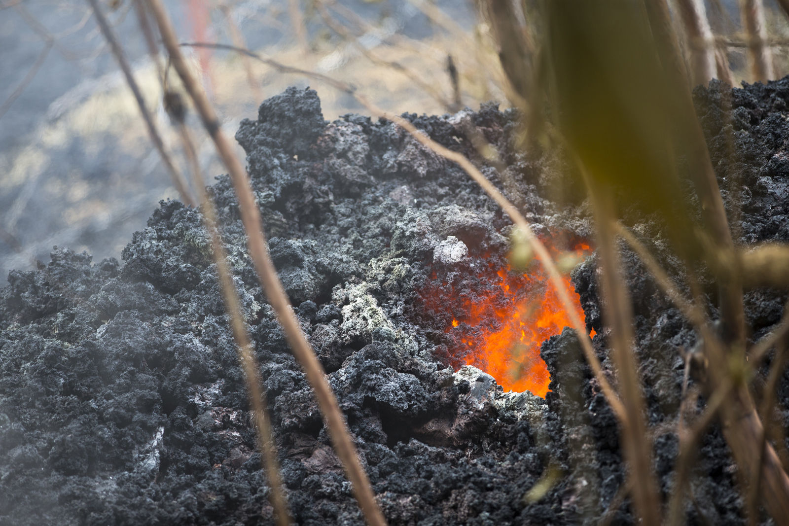 Lava glows from a vent on a lava bed at the Leilani Estates, Saturday, May 5, 2018, in Pahoa, Hawaii. The Hawaiian Volcanoes Observatory said eight volcanic vents opened in the Big Island residential neighborhood of Leilani Estates since Thursday. (AP Photo/Marco Garcia)