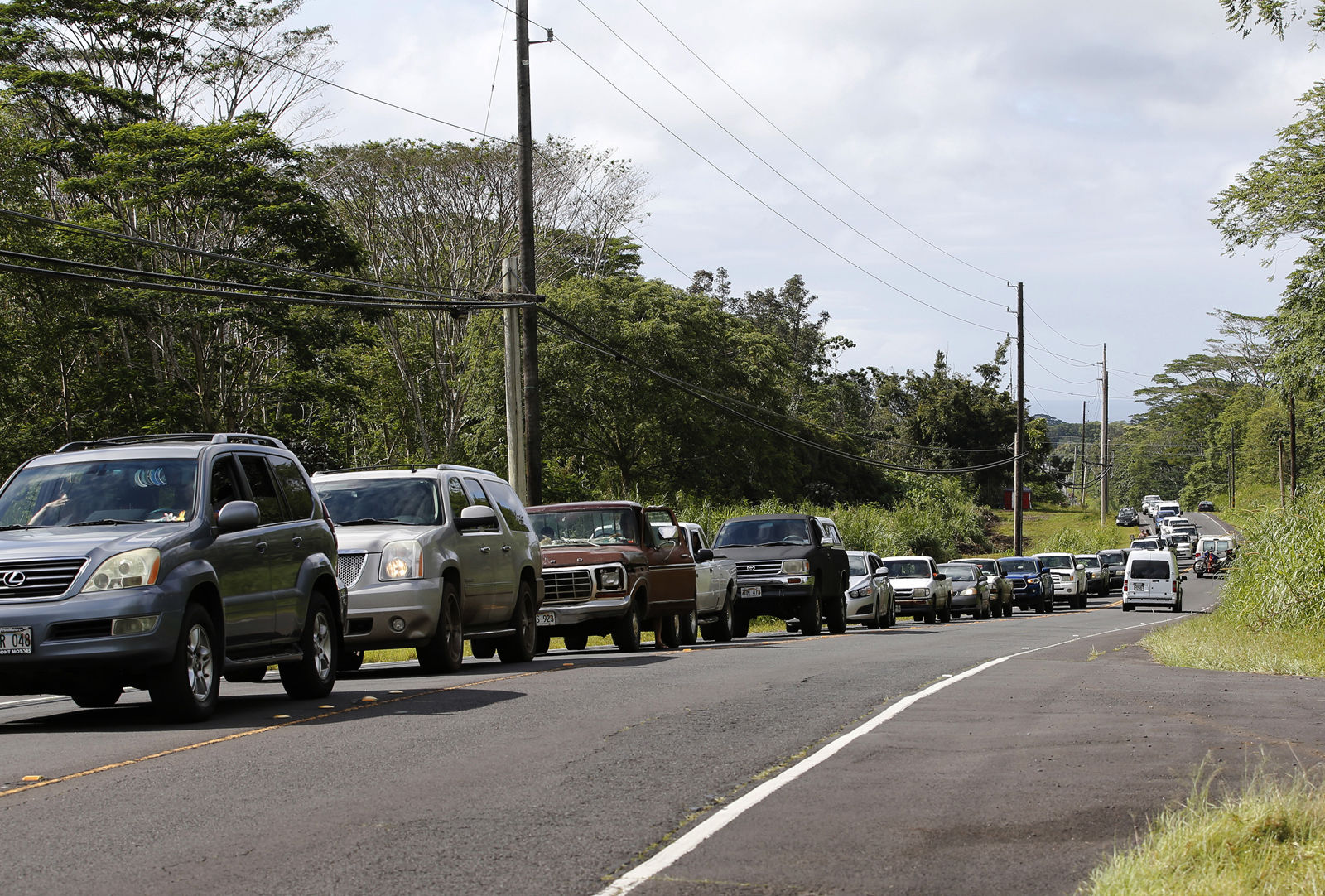 Residents of the Leilani Estates queue in a line to enter the subdivision to gather possessions from their homes, Sunday, May 6, 2018, in Pahoa, Hawaii. Scientists reported lava spewing more than 200 feet (61 meters) into the air in Hawaii's recent Kilauea volcanic eruption, and some of the more than 1,700 people who evacuated prepared for the possibility they may not return for quite some time. (AP Photo/Marco Garcia)