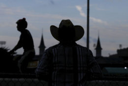 A worker watches during morning workouts at Churchill Downs Friday, May 4, 2018, in Louisville, Ky. The 144th running of the Kentucky Derby is Saturday, May 5th. (AP Photo/Kiichiro Sato)