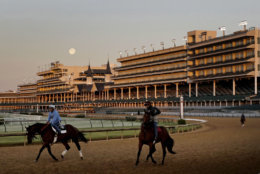 The full moon sets beyond the grandstands at Churchill Downs as horses work on the track Monday, April 30, 2018, in Louisville, Ky. The 144th running of the Kentucky Derby is scheduled for Saturday, May 5. (AP Photo/Charlie Riedel)