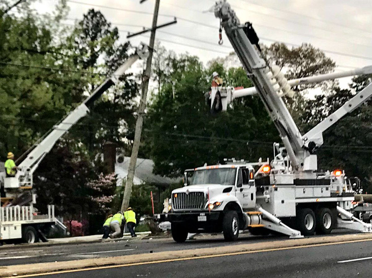 Pepco crews work to replace a power pole damaged in a multicar crash along New Hampshire Avenue in Langley Park. (WTOP/Neal Augenstein)