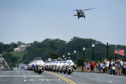 A military helicopter flies over a police escort on the Memorial Bridge, for motorcyclists riding in the 30th anniversary of the Rolling Thunder 'Ride for Freedom' demonstration in Washington, Sunday, May 28, 2017. Rolling Thunder seeks to bring full accountability for all U.S. prisoners of war and missing in action (POW/MIA) soldiers. (AP Photo/Cliff Owen)