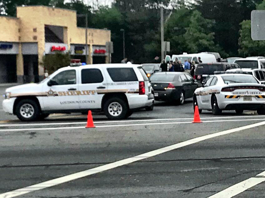 Detectives gathered around a car stopped after a double homicide at Pharaoh Cafe in Sterling, Virginia. (WTOP/Neal Augenstein)