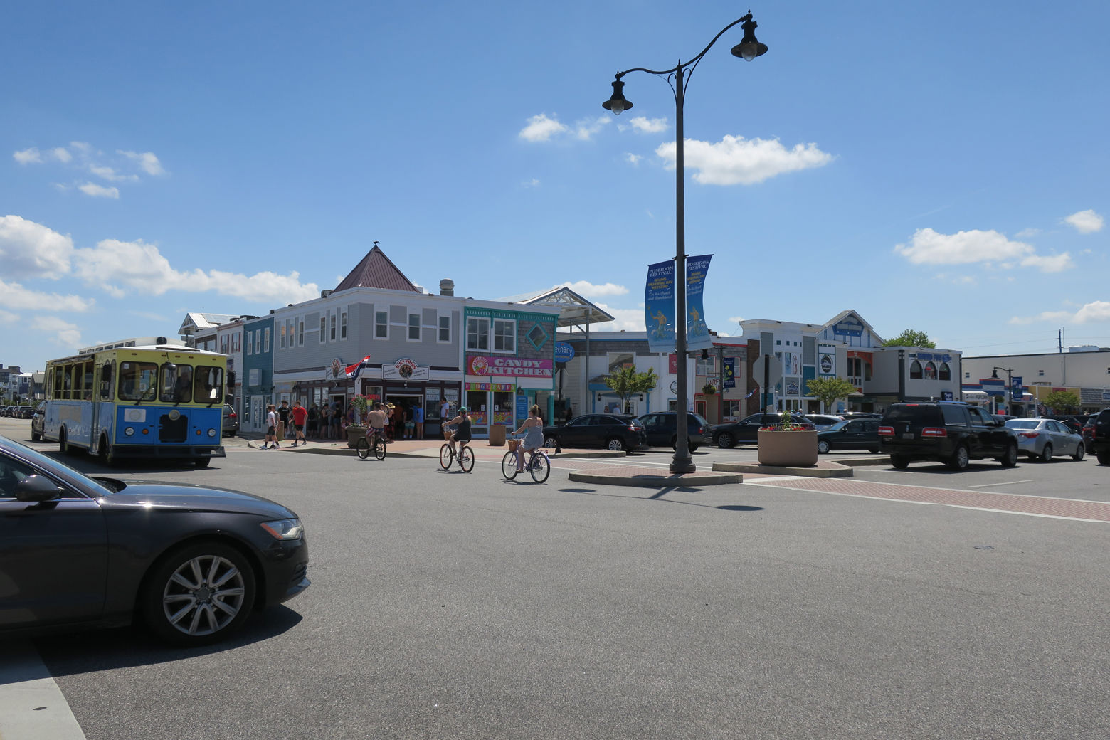Bethany Beach street with people biking and the trolley is seen
