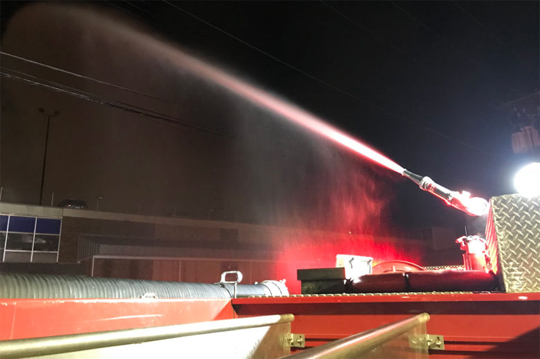 photo shows a fire hose spraying on a warehouse fire in DC
