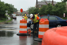 A worker sets construction barrels on Ravensworth Road ahead of the installation of a mini roundabout. (Courtesy VDOT)